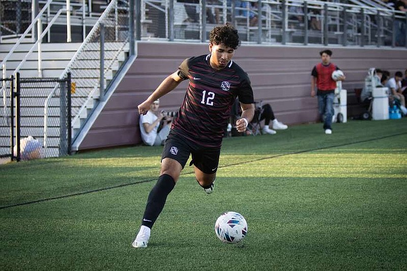 Photo courtesy of Krystal Elmore Siloam Springs soccer player Anthony Sandoval moves the ball against Mountain Home on April 12.