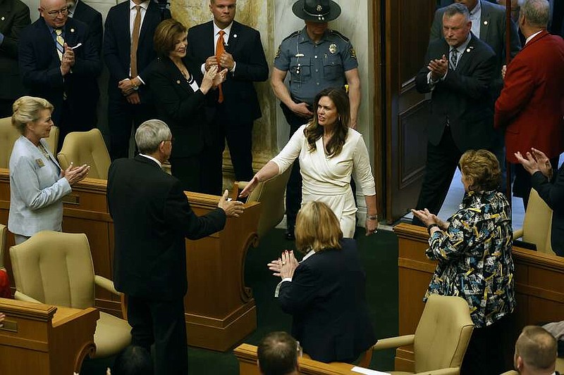 Gov. Sarah Huckabee Sanders (center) is greeted by Rep. Jack Ladyman, R-Jonesboro, and the rest of the legislature as she enters the House chamber to give the State of the State address on Wednesday, April 10, 2024, at the state Capitol in Little Rock.
(Arkansas Democrat-Gazette/Thomas Metthe)
