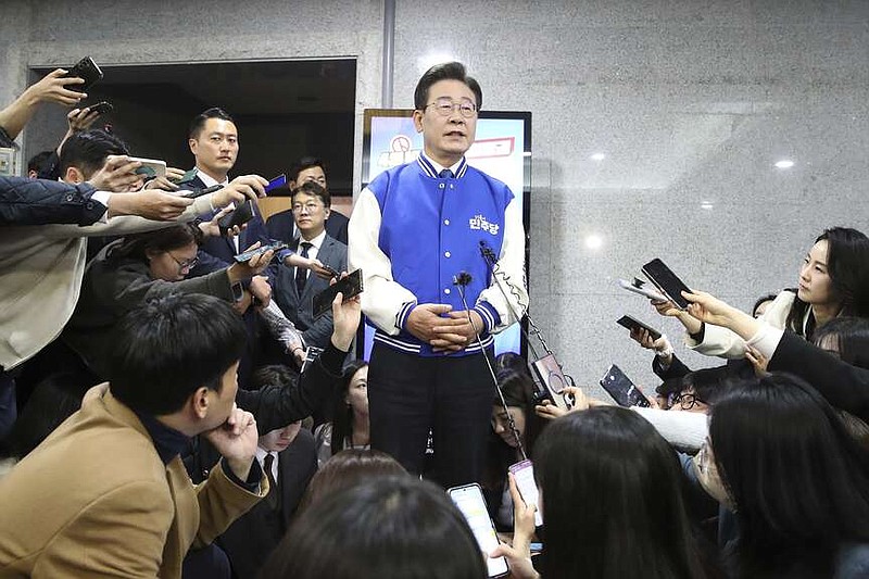 South Korea's main opposition Democratic Party (DP) leader Lee Jae-myung, center, speaks to reporters after watching TV broadcasting results of exit polls for the parliamentary election at the National Assembly on Wednesday, April 10, 2024 in Seoul, South Korea. (Chung Sung-Jun/Pool Photos via AP)