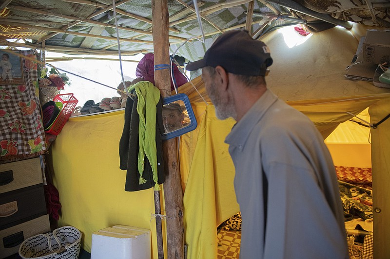Allal Oli Lahcen stands inside his tent after he was displaced by the earthquake, in Amizmiz, near Marrakech, Thursday, April 4, 2024. (AP Photo)