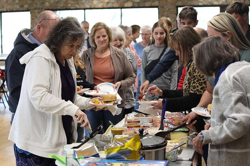 Ryan Pivoney/News Tribune
Monica Readenour, left, leads a line of volunteers down the potluck food table Thursday during Jefferson City Room at the Inn's celebration for supporters at McClung Park. The event was aimed at recognizing the nonprofit's volunteers and discussing next steps.