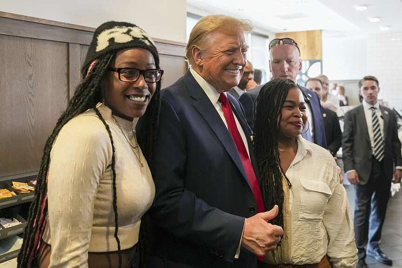 Republican presidential candidate former President Donald Trump, center, takes a photo with Michaelah Montgomery, left, a local conservative activist, as he visits a Chick-fil-A eatery on Wednesday, April 10, 2024, in Atlanta. (AP Photo/Jason Allen)