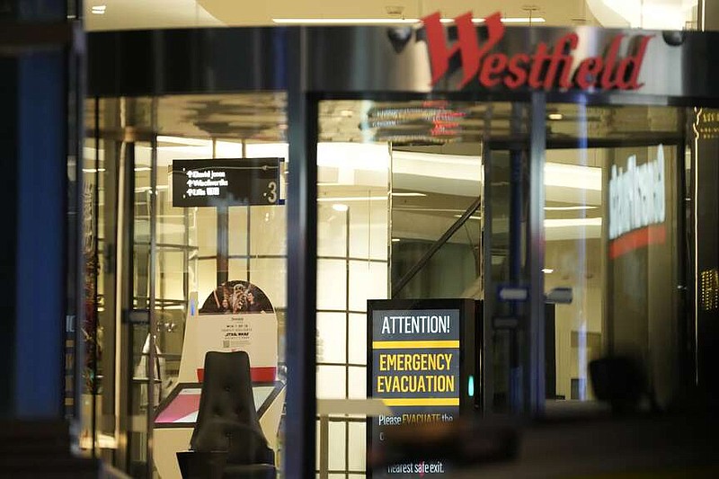 A sign to evacuate is seen at Westfield Shopping Centre, where multiple people were stabbed in Sydney, Saturday, April 13, 2024. Five people and a suspect were killed in a Sydney shopping center stabbing attack on Saturday that left multiple people, including a small child, injured, police said. (AP Photo/Rick Rycroft)
