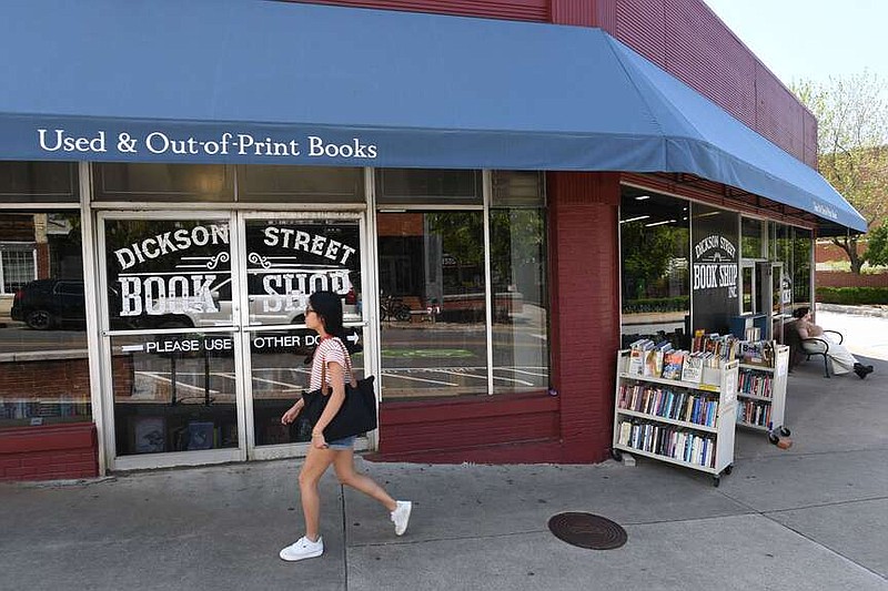 A pedestrian walks Friday past the Dickson Street Bookshop on Dickson Street in Fayetteville. The founders of the 46-year-old business have passed away. Suedee Hall Elkins, who has managed the bookstore for several years, is the new owner. Visit nwaonline.com/photo for today's photo gallery.
(NWA Democrat-Gazette/Andy Shupe)