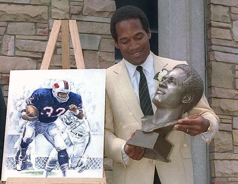 FILE - O.J. Simpson checks out the bronze bust of himself after his induction into the Pro Football Hall of Fame Saturday, Aug. 3, 1985 in Canton, Ohio. O.J. Simpson, the decorated football superstar and Hollywood actor who was acquitted of charges he killed his former wife and her friend but was found liable in a separate civil trial, has died. He was 76. The family announced on Simpson's official X account that he died Wednesday, April 10, 2024, of prostate cancer. (AP Photo/Ernie Mastroianni, File)