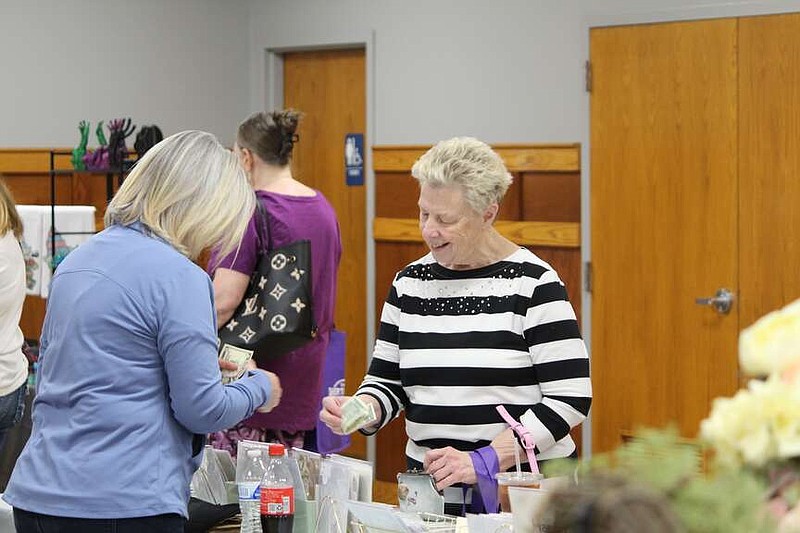 Ryan Pivoney/News Tribune
Peggy Luebbert pays Marlene Stiefermann for a handmade graduation card during the Spring Fling event Sunday at the Wardsville Lions Club. Approximately 28 vendors participated in the event, with proceeds going to support Cole County Relay for Life.