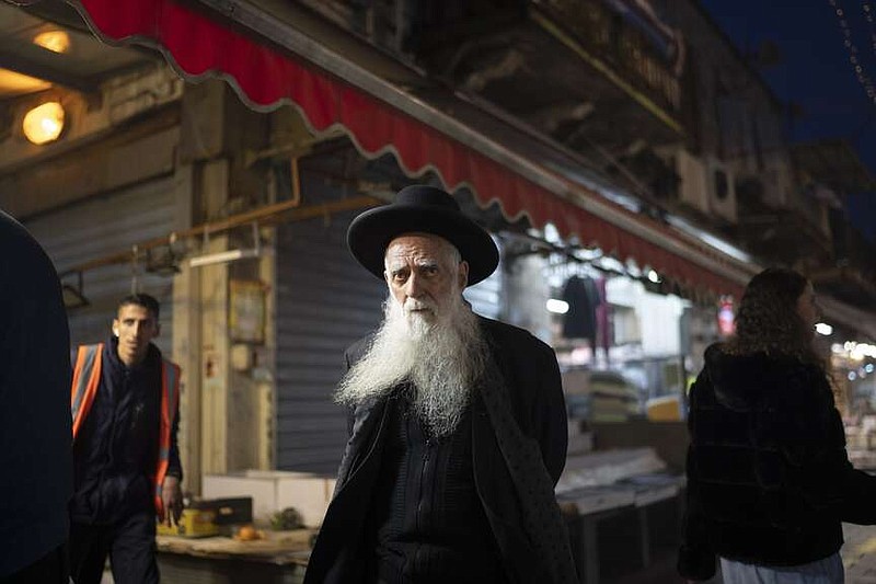 An elderly ultra-Orthodox Jewish man looks on as he walks in the Mahane Yehuda market in Jerusalem on Sunday. Israel on Sunday hailed its air defenses in the face of an unprecedented attack by Iran, saying the systems thwarted 99% of the more than 300 drones and missiles launched toward its territory. (AP Photo/Leo Correa)