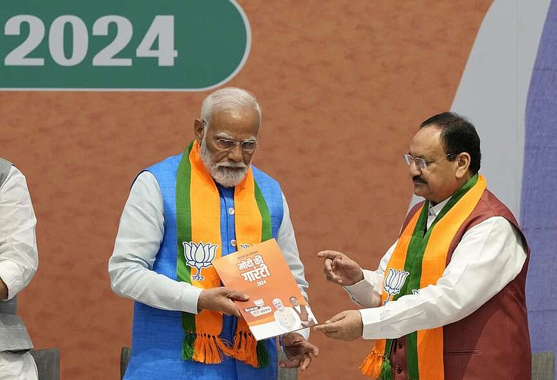 Indian Prime Minister Narendra Modi receives his Bharatiya Janata Party's manifesto from BJP President JP Nadda, right, ahead of the upcoming national parliamentary elections in New Delhi, India, Sunday, April 14, 2024. Modi vowed to boost social spending, develop world-class infrastructure, and make India a global manufacturing hub as he unveiled his Hindu nationalist party's election manifesto on Sunday. (AP Photo/Manish Swarup)