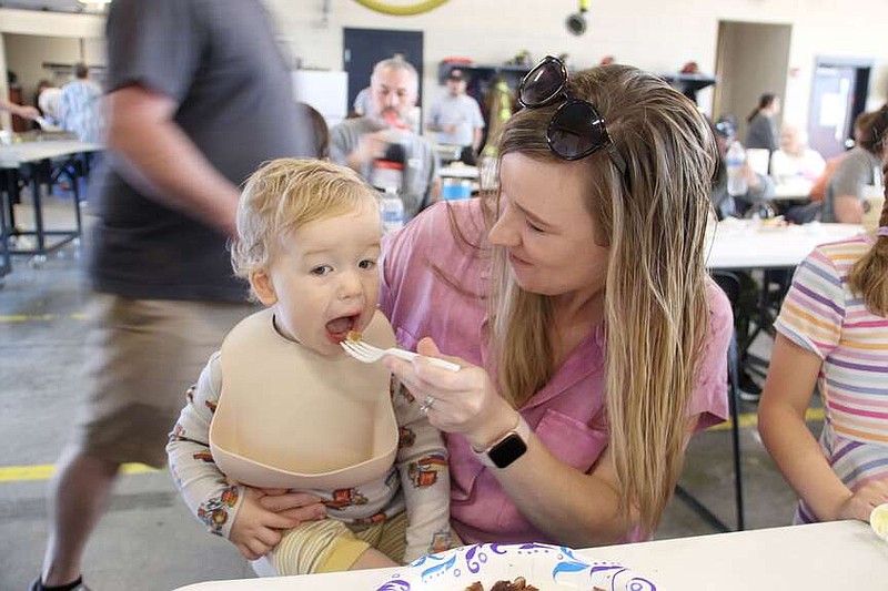 Lynn Kutter/Enterprise-Leader
Crew Denman, 1, of Prairie Grove, opens wide for a bite of pancakes from his mother, Megan Denman, during the annual Farmington Fire Department pancake breakfast on Saturday. About 1,000 people showed up during the morning for pancakes, bacon and sausage. The fire department thanked its sponsors for the breakfast: Hunt Rogers Group, Walmart Neighborhood Market in Farmington, Tysons Foods, Hiland Dairy, Starbucks and Farmington Mayor Ernie Penn.