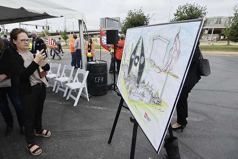 Sarah Stillman, Arkansas chapter president of the American Traffic Safety Services Association, takes a picture of the rendering for the for a fallen transportation department workers monument that was announced on Monday, April 15, 2024, in Little Rock. (Arkansas Democrat-Gazette/Thomas Metthe)