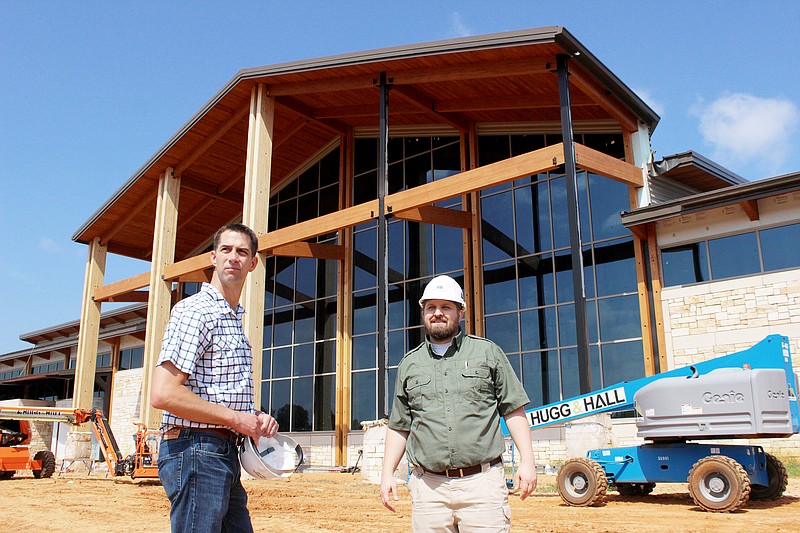 U.S. Sen. Tom Cotton, R-Ark., left, and airport Executive Director Paul Mehrlich look at site work on the parking lot for the new passenger terminal, background, at Texarkana Regional Airport on Aug. 10, 2023, in Texarkana, Ark. (Staff file photo by Stevon Gamble)