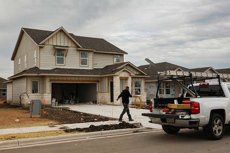 Workers in front of a home under construction in Kyle, Tex., on March 18, 2024. MUST CREDIT: Jordan Vonderhaar/Bloomberg