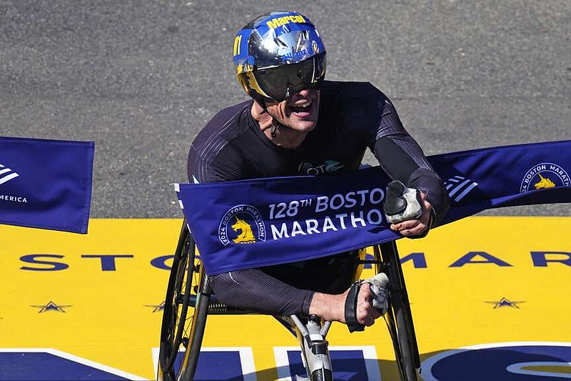 Marcel Hug of Switzerland breaks the tape to win the men's wheelchair division at the Boston Marathon, Monday, April 15, 2024, in Boston. (AP Photo/Charles Krupa)