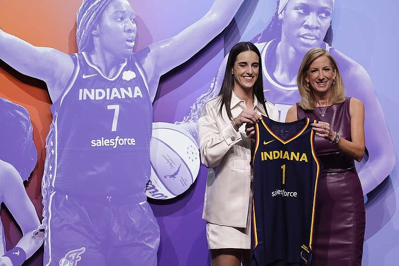 Iowa's Caitlyn Clark, left, poses for a photo with WNBA commissioner Cathy Engelbert after being selected first overall by the Indiana Fever during the first round of the WNBA basketball draft, Monday, April 15, 2024, in New York. (AP Photo/Adam Hunger)