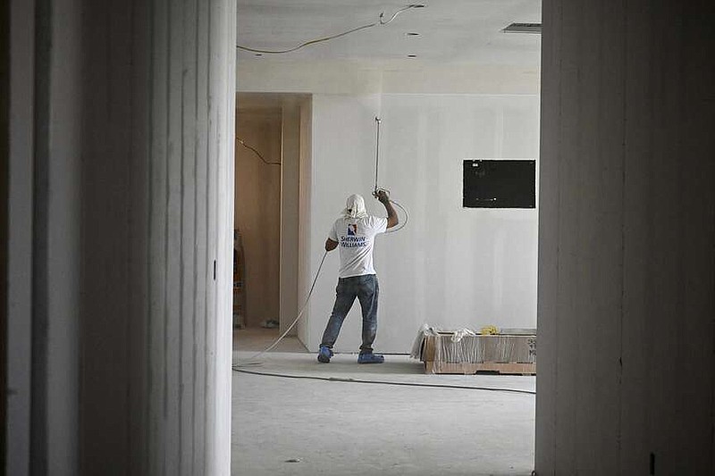 A construction worker paints the walls of the office area inside the 20,000-square-foot Stella Boyle Smith Music Center, which is under construction in the East Village, during a tour of the facility on Tuesday, April 16, 2024.(Arkansas Democrat-Gazette/Stephen Swofford)