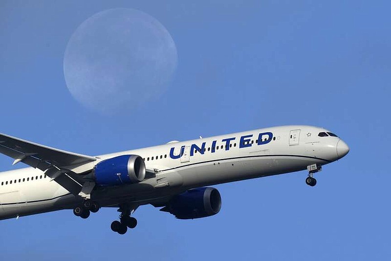 FILE - A United Airlines Boeing 787 approaches for landing in Lisbon, Sept. 2, 2023, with the setting moon in the background.  United Airlines reports their earnings on Tuesday, april 16, 2024.   (AP Photo/Armando Franca, File)