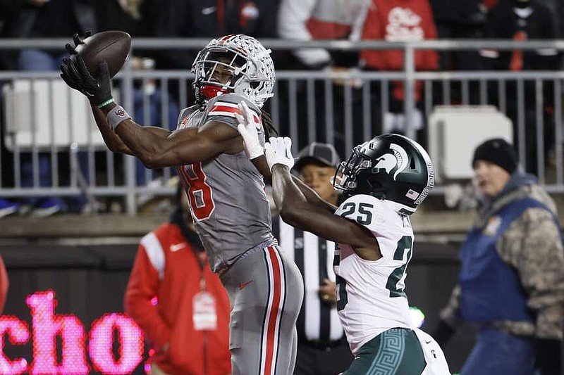 FILE - Ohio State receiver Marvin Harrison, left, catches a touchdown pass over Michigan State defensive back Chance Rucker during the first half of an NCAA college football game Saturday, Nov. 11, 2023, in Columbus, Ohio. Harrison Jr. is a possible first round pick in the NFL Draft.(AP Photo/Jay LaPrete, File)