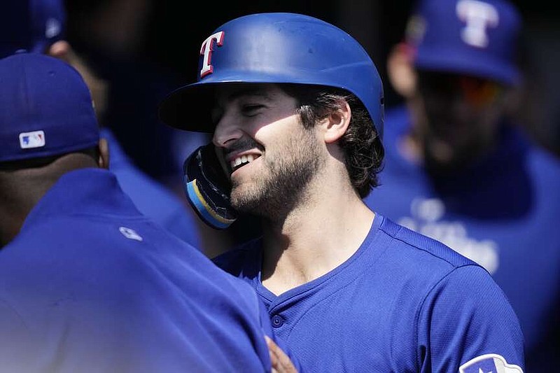 Texas Rangers' Josh Smith is greeted in the dugout after scoring from third on a single by designated hitter Ezequiel Duran during the fifth inning of a baseball game against the Detroit Tigers, Tuesday, April 16, 2024, in Detroit. (AP Photo/Carlos Osorio)