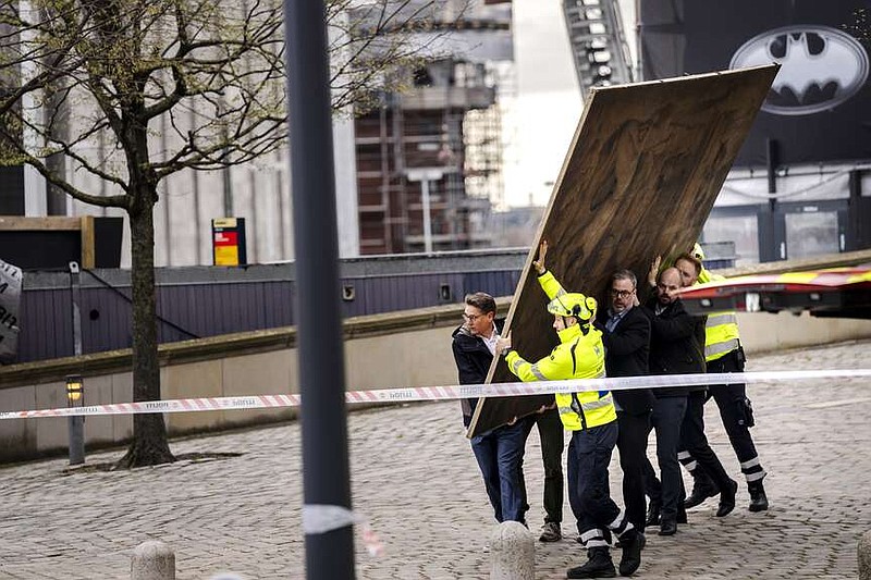 CEO of Danish Business, Brian Mikkelsen, and others carry paintings out of the burning building as the Stock Exchange burns in Copenhagen, Denmark, Tuesday, April 16, 2024. A fire raged through one of Copenhagen's oldest buildings on Tuesday, causing the collapse of the iconic spire of the 17th-century Old Stock Exchange as passersby rushed to help emergency services save priceless paintings and other valuables. (Ida Marie Odgaard/Ritzau Scanpix via AP)