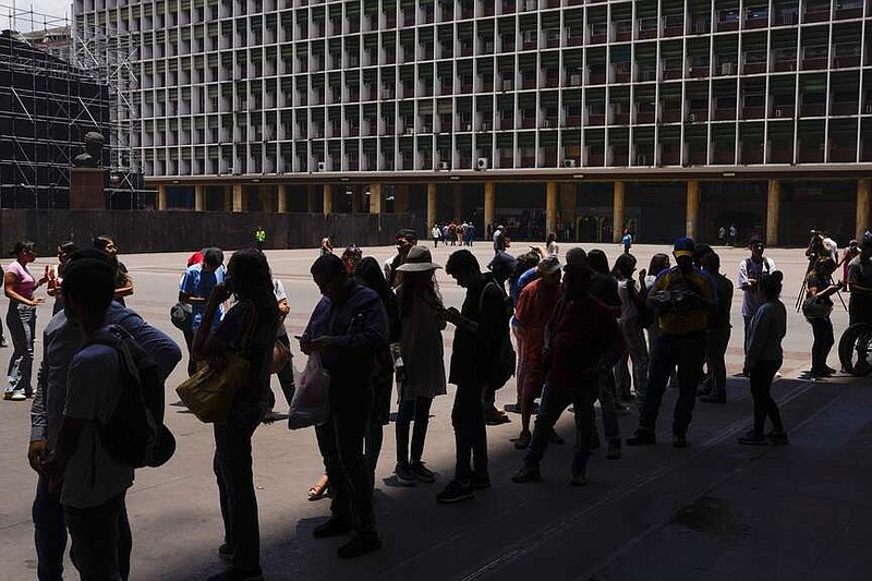 People wait in line to register to vote in the upcoming presidential election in Caracas, Venezuela, Tuesday, April 16, 2024. Voters go to the polls on July 28th. (AP Photo/Ariana Cubillos)