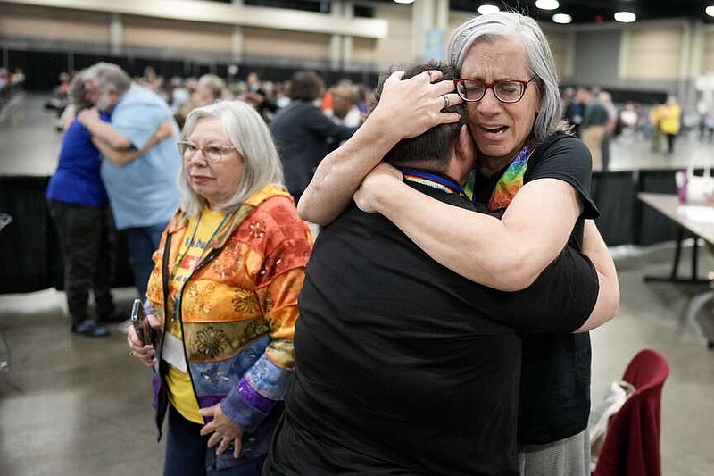 Angie Cox, left, and Joelle Henneman hug after an approval vote at the United Methodist Church General Conference Wednesday, May 1, 2024, in Charlotte, N.C.  United Methodist delegates repealed their church's longstanding ban on LGBTQ clergy with no debate on Wednesday, removing a rule forbidding “self-avowed practicing homosexuals” from being ordained or appointed as ministers.(AP Photo/Chris Carlson)