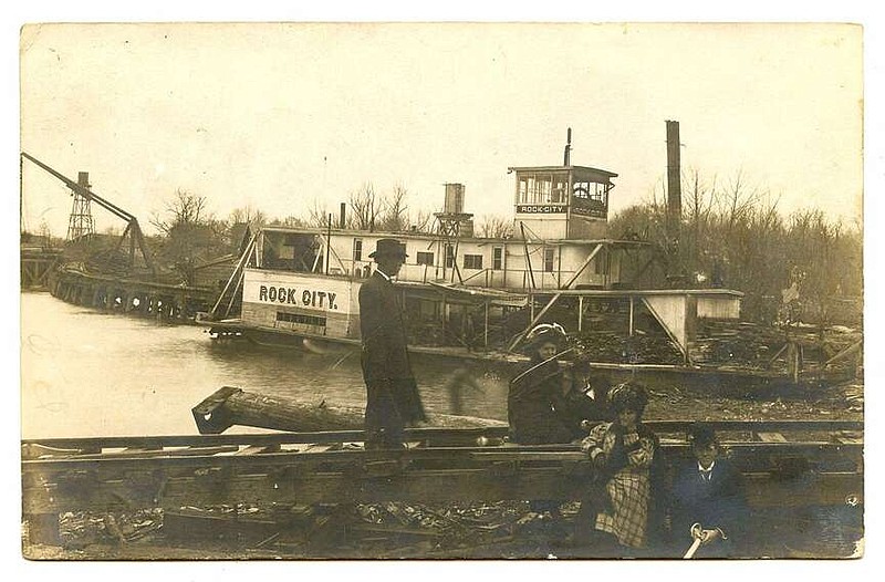 Des Arc, 1908: “I will send you an Ark. card showing a log boat and White River.” The Rock City paddlewheel boat was parked in front of a sawmill, across the river from people posed on the railroad tracks. The flat cargo areas of the boat were stacked with lumber.

Send questions or comments to Arkansas Postcard Past, P.O. Box 2221, Little Rock, AR 72203