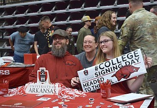 A graduating senior celebrates her commitment to the University of Arkansas with guests that attended signing day. (The Sentinel-Record/Donald Cross)