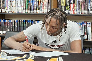 Watson Chapel senior Kaylon Cannon signs a national letter of intent to play men's basketball at North Arkansas College in the WCHS library Wednesday. (Pine Bluff Commercial/Tanner Spearman)