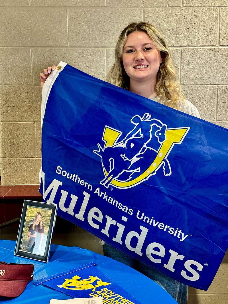 Recent Lake Hamilton High School graduate Jordyn Garner holds a Southern Arkansas University banner on Wednesday at Wolf Arena before signing to commit to the school's golf team. (The Sentinel-Record/Bryan Rice)