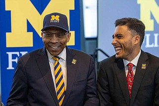Newly appointed University of Michigan-Flint Chancellor Laurence B. Alexander, left, is introduced and seated next to an unidentified man on campus at a May 16 event. (Special to The Commercial/University of Michigan-Flint)