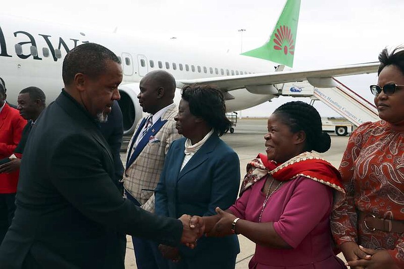 Malawi Vice President Saulos Chilima, left, greets government officials upon his return from South Korea in Lillongwe, Sunday, June 9, 2024. A military plane carrying Malawi's vice president and nine others went missing Monday and a search was underway, the president's office said. The plane carrying 51-year-old Vice President Saulos Chilima left the capital, Lilongwe, but failed to make its scheduled landing at Mzuzu International Airport about 370 kilometers (230 miles) to the north around 45 minutes later. (AP Photo)