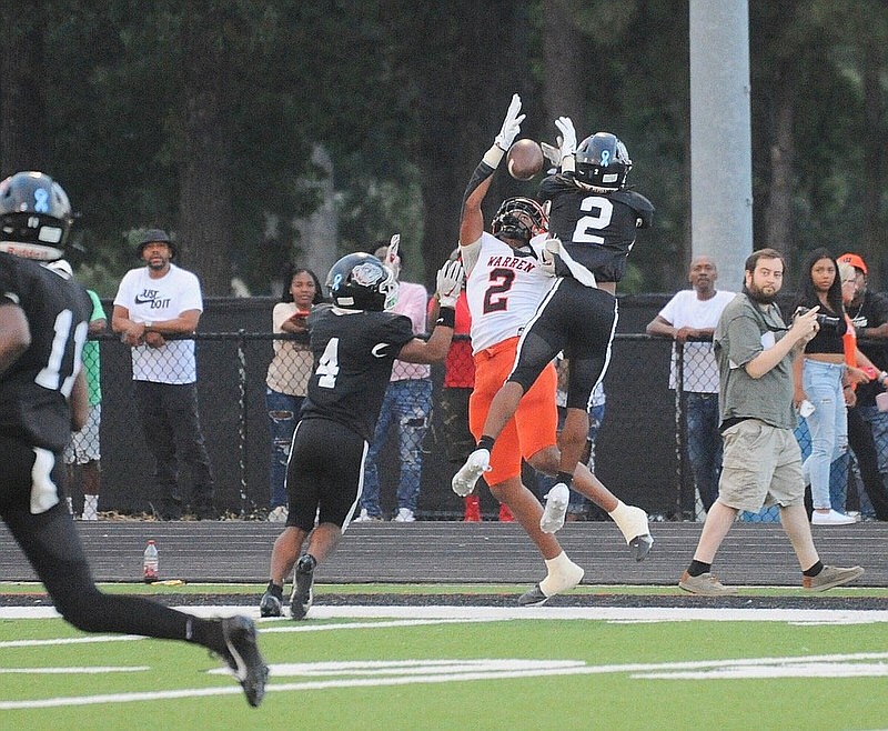 Warren's Antonio Jordan goes high for a pass as White Hall's Braeden Bell (2) and Kyen Weston (4) try to break up the play. (Special to The Commercial/William Harvey)