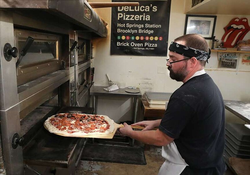 A Deluca's employee puts a pie into the oven at the Hot Springs pizzeria. Deluca's is one of 35 pizzerias, and the only one in the South, selected to participate in Dave Portnoy's One Bite Pizza Festival in September.

(Hot Springs Sentinel-Record file photo)