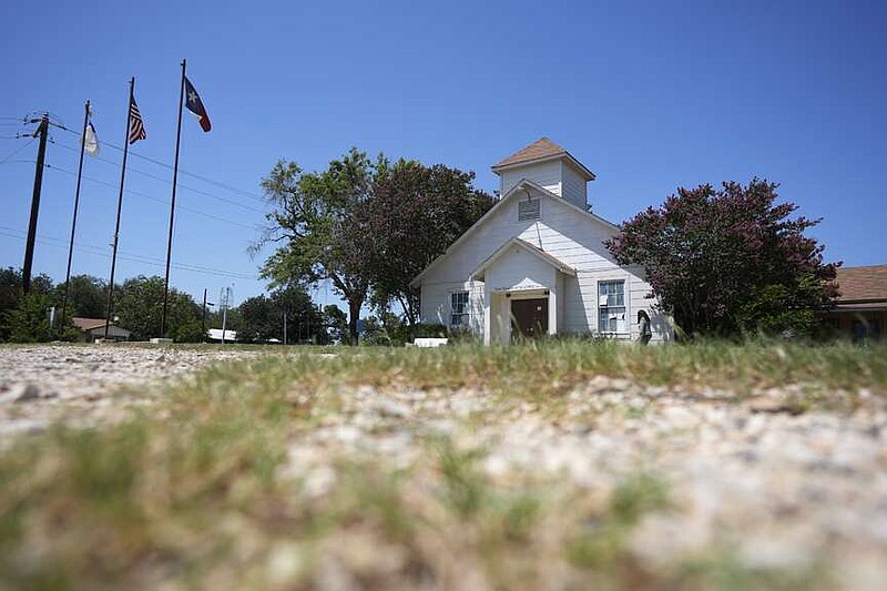 A woman visits the First Baptist Church in Sutherland Springs, Texas, Tuesday, July 2, 2024, which is now a memorial to the 26 people who were killed by a gunman in 2017. The 100-year-old building has served as a memorial since the shooting, but now some want to raze the building. (AP Photo/Eric Gay)