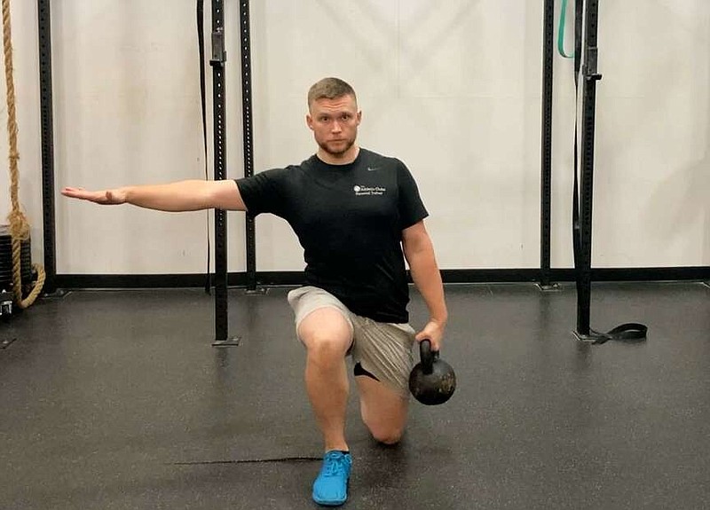 In this first of three photos, JD Stephenson demonstrates Kettlebell Suitcase for Matt Parrott's Master Class. (Arkansas Democrat-Gazette/Kimberly Dishongh)