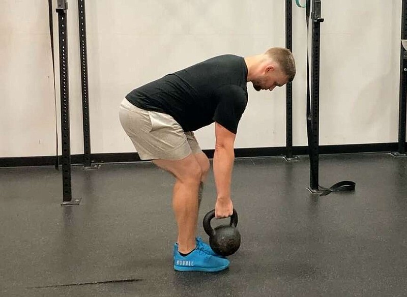 In this first of three photos, JD Stephenson, a personal trainer with the Little Rock Athletic Club, demonstrates the Kettlebell Bent Over Row for Matt Parrott's Master Class. (Arkansas Democrat-Gazette/Kimberly Dishongh)