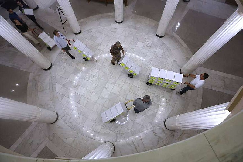 Volunteers wheel boxes of signatures for the casino amendment into the state Capitol July 5, 2024. (Arkansas Democrat-Gazette/Thomas Metthe)