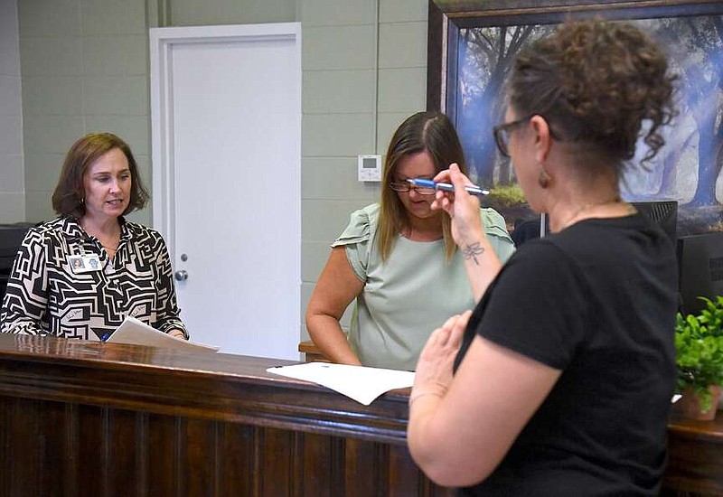 From left, City Clerk Harmony Morrissey and Deputy City Clerk Leigh Leaverton watch as District 1 Director Erin Holliday files for the November election Wednesday at City Hall. She's one of three incumbents who filed for re-election to the Hot Springs Board of Directors. (The Sentinel-Record/Donald Cross)