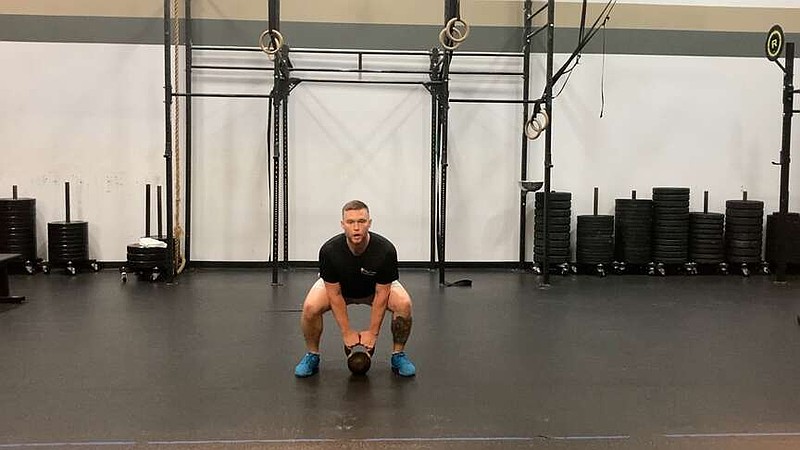 n this first of three photos, JD Stephenson, personal trainer at the Little Rock Athletic Club, demonstrates the Kettlebell Frogger for Matt Parrott's Master Class. (Arkansas Democrat-Gazette/Kimberly Dishongh)