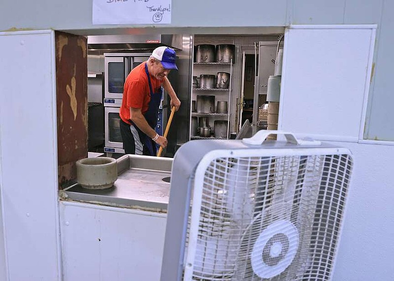 A box fan helps keep Gregg Pigg cool as he helps clean the kitchen at the Little Rock Compassion Center as temepratures in the region approached 100 degrees Monday, June 24, 2024. Cooling centers are open at the compassion center and community centers including Dunbar, East LR, Southwest, Stephens and West Central. In North Little Rock, a cooling center is open Monday and Tuesday from 10 am to 6 pm at 2700 Willow Street. (Arkansas Democrat-Gazette/Colin Murphey)