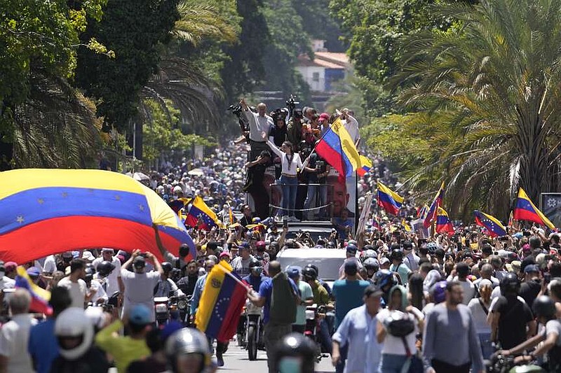 Opposition leader Maria Corina Machado waves a national flag as she waves to supporters during a rally in Caracas, Venezuela, Saturday, Aug. 3, 2024. (AP Photo/Matias Delacroix)