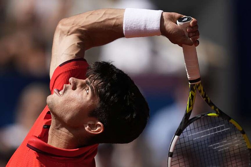 Spain's Carlos Alcaraz serves to Serbia's Novak Djokovic during the men's singles tennis final at the Roland Garros stadium during the 2024 Summer Olympics, Sunday, Aug. 4, 2024, in Paris, France. (AP Photo/Louise Delmotte)