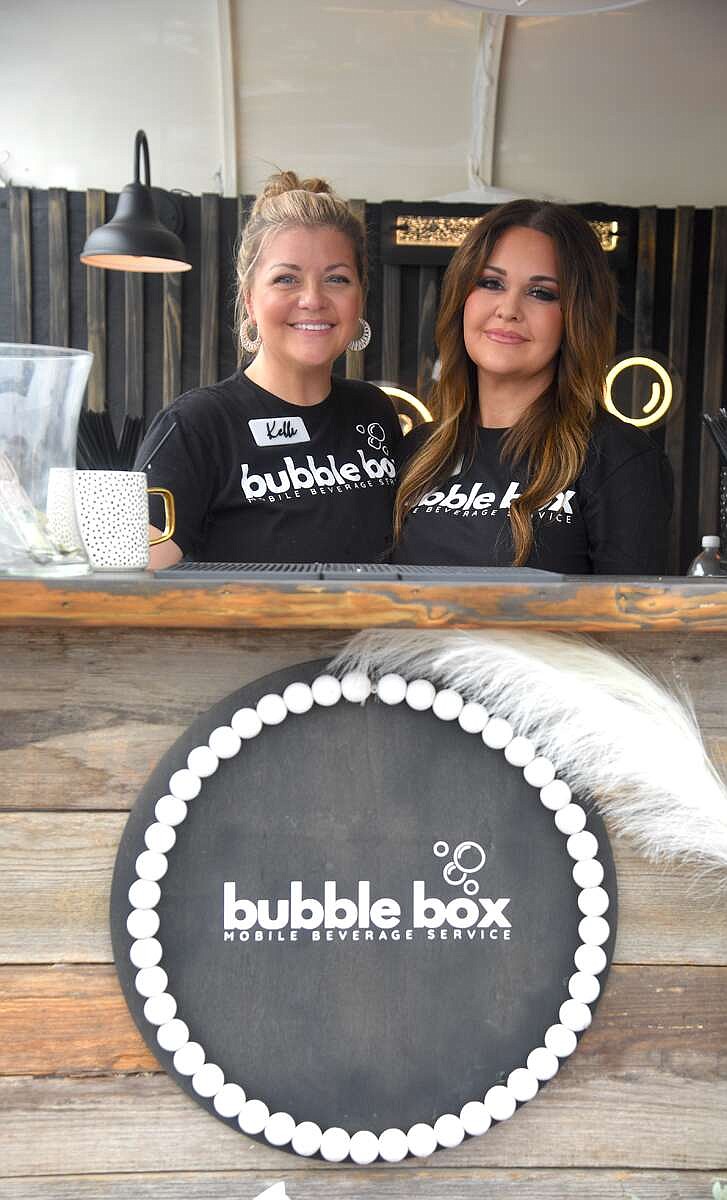 Bubble Box owner Kelli Palmer, left, and Jennifer Smedley work together to serve drinks at the mobile bar.