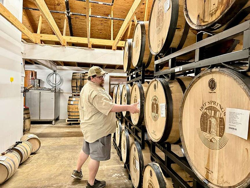 Hot Springs Distillery owner and distiller Scott Atkinson checks barrels of Bear Clap Bourbon. (The Sentinel-Record/Bryan Rice)