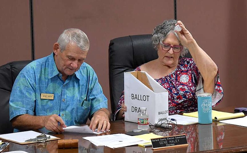 Garland County Election Commission Chairman/Election Coordinator Gene Haley, left, and Commissioner Kay Ekey conduct Friday's ballot draw at the Election Commission Building. (The Sentinel-Record/Donald Cross)