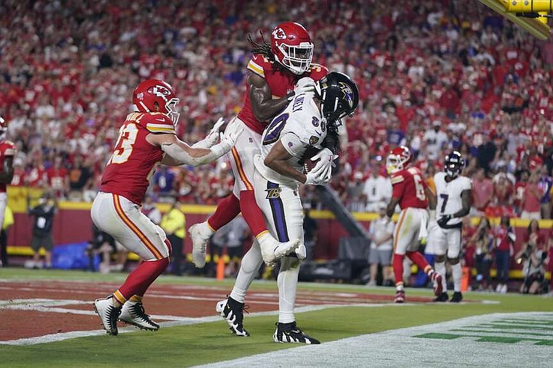 Baltimore Ravens tight end Isaiah Likely (80) catches a pass with his toe out of bounds as Kansas City Chiefs linebacker Nick Bolton  and linebacker Drue Tranquill, left, defend as time time expires in the second half of an NFL football game Thursday, Sept. 5, 2024, in Kansas City, Mo. The Chiefs won 27-20.(AP Photo/Ed Zurga)