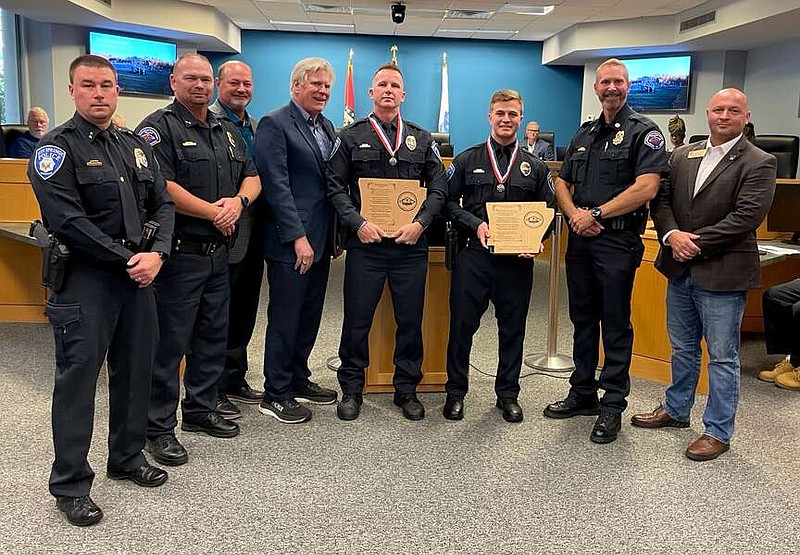 From left, Hot Springs Police Chief Billy Hrvatin, Arkansas Commission on Law Enforcement Standards and Training Director Chris Chapmond, City Manager Bill Burrough, Mayor Pat McCabe, Officer Alexander Lee, Officer Nicolas Cato, CLEST Deputy Director Jason Lawrence and state Sen. Matt McKee, R-District 6, are shown a presentation at City Hall Tuesday night. (Courtesy city of Hot Springs)