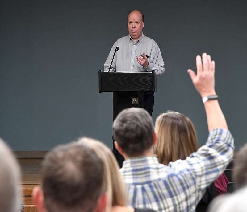 Hot Springs Planning Commission Chairman Bart Stafford raises his hand to ask District 1 city director candidate Mark Toth a question at the candidates forum the Garland County Library held Wednesday. (The Sentinel-Record/Donald Cross)