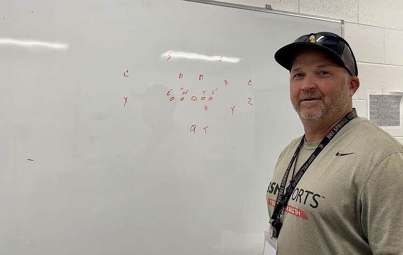 Hot Springs World Class High School offensive coordinator Brian Hembree discusses a run play while in the Trojans coaches' offices on Oct. 12. (The Sentinel-Record/Bryan Rice)