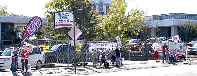 Candidates in next month's election hold campaign signs Monday in front of the Garland County Election Commission Building. (The Sentinel-Record/Donald Cross)